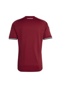 Maglietta a maniche corte color bordeaux con accenti a strisce verdi e bianche sulle maniche. Tessuto liscio, colletto tondo e "MAGYARORSZÁG" stampato sul retro.