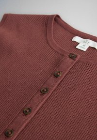 Ribbed knit brown cardigan with round neckline, five brown buttons down the front, and a clothing label showing size M.