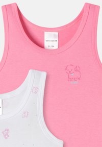 Twee mouwloze tops: één roze met een puppygraphic en de tekst "ZO SCHOON!"; de andere wit met meerkleurige puppypatronen. Beide zijn van katoen.