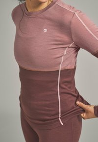 Long-sleeve performance top in gradient shades of mauve, with contrasting light seams and a fitted design for comfort and mobility.