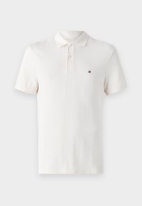 Kremo spalvos polo marškiniai su tekstūruotu raštu, trijų mygtukų užsegimu ir mažąja logotipo ženklu kairiajame krūtinės srityje. Trumpomis rankovėmis.