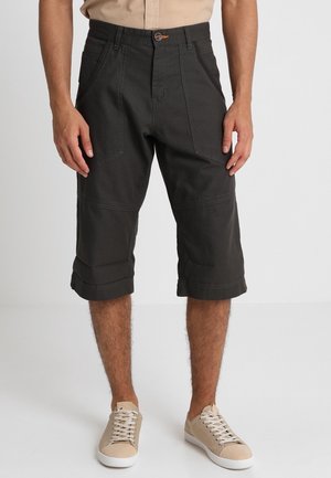 Donkergroene cargoshorts met een losse pasvorm, opvallende voorzakken, opgerolde zomen en een stevige katoenmixstof.