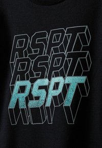 Melnas auduma krekls ar spilgtu, stilizētu tekstu "RSPT" piparmētru zaļā krāsā ar punktainu faktūru, sakārtots kaudzē.
