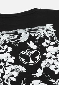 Zwarte katoenen T-shirt met witte bloem- en vlindergraphics, met een centraal embleem, ronde halslijn en korte mouwen.