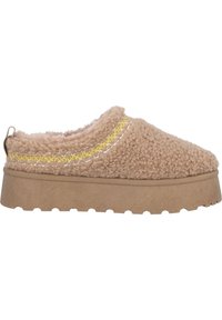 Zapatos de slip-on de color beige, con una superficie fuzzy y textura, que presentan acentos de costura amarilla y blanca, y una suela de goma robusta en tono marrón.