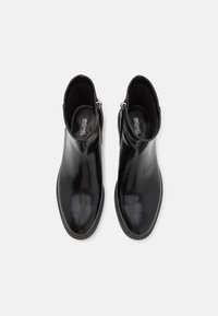 Black leather ankle boots with a sleek design, round toe, and side zip closure. Smooth texture with ribbed soles for added grip.