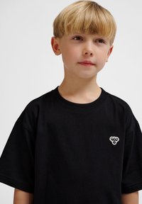 Schwarzes Baumwoll-T-Shirt mit kurzen Ärmeln, rundem Ausschnitt und kleinem gesticktem Logo auf der linken Brust. Weicher Stoff, klassischer Schnitt.