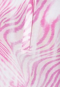 Tissu imprimé zèbre rose et blanc avec un détail de fente verticale dissimulée au centre.