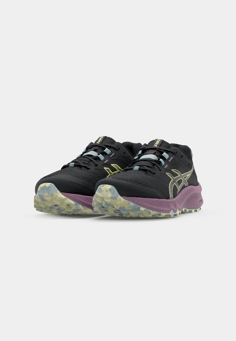 Scarpe da ginnastica nere con tomaia testurizzata, dettagli gialli e imbottitura viola. Presentano una suola robusta per una maggiore aderenza.