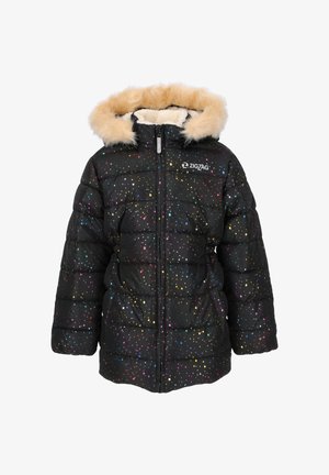 Lille barn smilende, iført en sort puffjakke med multicolor prikker, beige pelshætte, lilla leggings og sorte gummistøvler.