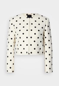 Cropped jacket in cream fabric with black polka dots. Features long sleeves, a round neckline, and a front closure. Textured finish.