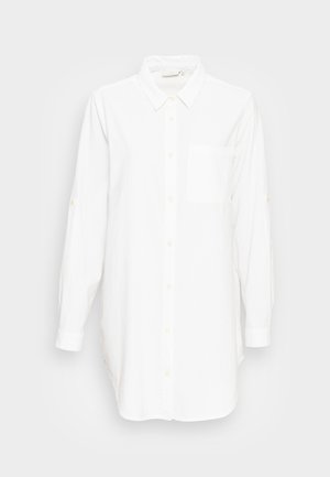Camisa branca de botão de mangas longas com colarinho e bolso no peito, exibida sobre um fundo cinza claro liso.