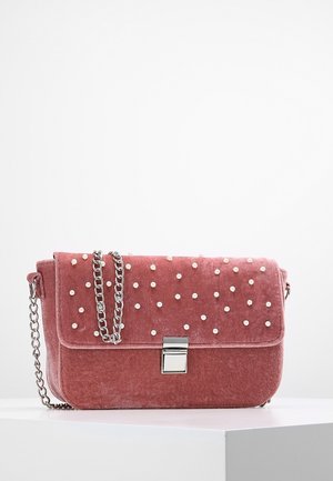 Roze fluwelen rechthoekige handtas met zilveren kettingband, kleine metalen sluiting en verspreide parelachtige studs op de klep.