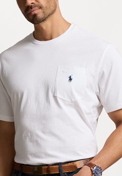 Λευκό βαμβακερό T-shirt με τσέπη στο στήθος, που διαθέτει μπλε κεντημένο λογότυπο αλόγου. Στρογγυλή λαιμόκοψη και κοντά μανίκια.