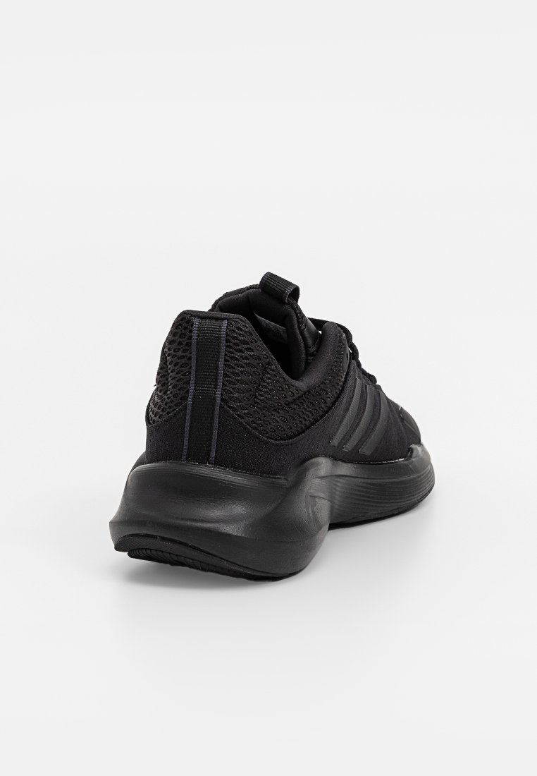 Zapatilla deportiva negra hecha de malla y materiales sintéticos, con una suela texturizada y un diseño de tres rayas en una forma aerodinámica y elegante.