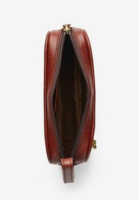 Rund, brun läderväska med dragkedja; texturerad utsida, slät foder och ett litet handtag på sidan för enkel bärning.