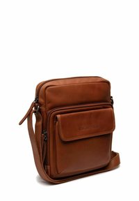 Borsa a tracolla in pelle marrone con scomparto principale con zip, tasca frontale, tracolla regolabile e texture liscia. Nessun accessorio hardware visibile.