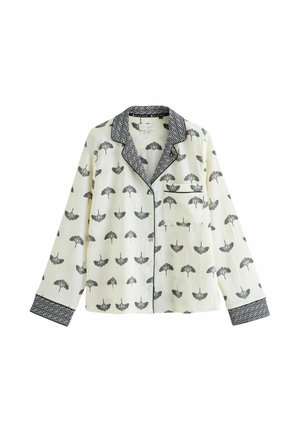 Dlhý rukáv pyžamová blúzka v svetlej krémovej farbe s čiernym vzorom dáždnika. Má čierny geometrický lem na golieri a manžetách, plus náprsníku.