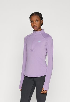 Pull-over violet clair à fermeture zippée au quart, en tissu doux, avec un ourlet incurvé et des trouspour les pouces. Petit logo sur la poitrine. Coupe près du corps.