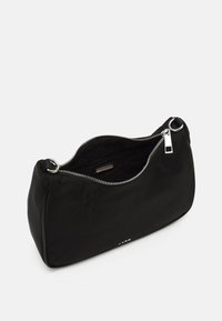 Sac à bandoulière en tissu noir doux avec une fermeture éclair argentée partiellement ouverte, montrant une poche intérieure et un détail de logo en métal sur le devant.