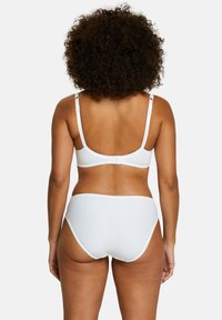 Ensemble de soutien-gorge blanc et de culotte taille haute, fabriqué en tissu lisse avec des bords festonnés. Bretelles réglables et fermeture à crochet au dos.