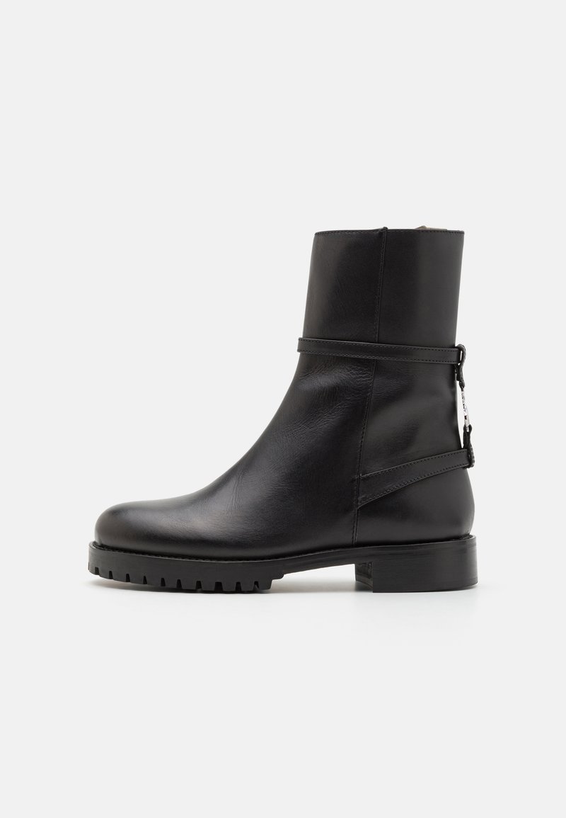 Černá kožená kotníková bota s kulatou špičkou, hladkým povrchem, bočním zipem a nízkou podrážkou s profilem, s minimalistickým designem.