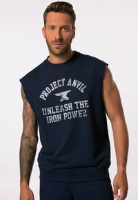Laivastonsininen hihaton huppari, jossa lukee "PROJECT ANVIL UNLEASH THE IRON POWER" kuluneen valkoisen printin muodossa. Pehmeä rakenne, pyöreä kaula-aukko, rento istuvuus.