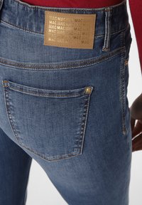 Denim jeans in medium blue, met een goudgeperst bruin label op de achterkant, decoratieve stiksels en standaard zakken.