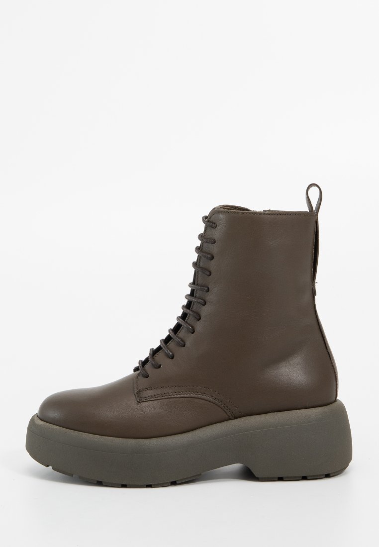 Brązowy skórzany botek za kostkę z czarnymi sznurówkami, grubą platformą i pętelką z tyłu, przedstawiony w profilu bocznym na białym tle.