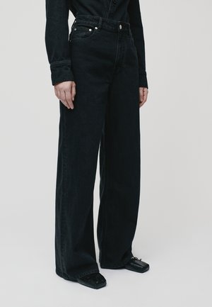 Zwarte high-waisted wide-leg jeans gemaakt van denim, met een knoopsluiting, voorzakken en een strakke, minimalistische uitstraling.