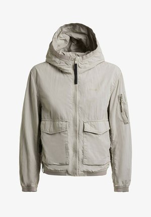 Light beige hooded jacket with front zipper, two large front flap pockets, and a zippered pocket on the left sleeve.