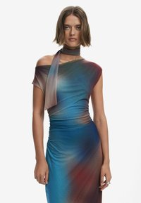 Asymmetrisches Kleid in einem Farbverlauf von Blau, Rot und Brauntönen, mit transparenter Textur und einem gewickelten Schal-Detail am Hals.