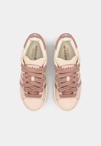 Light pink suede sneakers with darker pink accents and laces. Features a round logo on the tongue and three stripes on the sides.