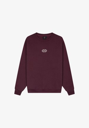 Donkerpaarse trui met lange mouwen en ronde hals, met een klein wit rond logo in het midden van de borst.