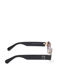 Gafas de sol rectangulares negras con lentes degradados, acentos metálicos y brazos de goma. Presentan el logotipo de la marca en la patilla y detalles de diseño únicos.