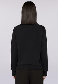 Svart sweatshirt med en enkel design, som har rund halsringning, långa ärmar och ett ribbat midjeband. Mjuk tyg med en slät yta.