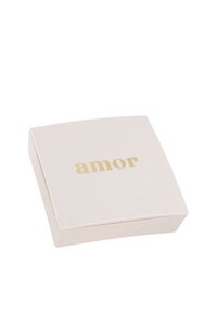 Pequeña caja de joyería cuadrada de color beige claro con el texto dorado "amor" centrado en la tapa, aislada sobre un fondo blanco.