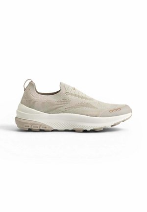 Hellbeiger Slip-On-Sneaker mit gestricktem Obermaterial, gepolstertem Kragen und strukturierter Sohle für den Freizeitgebrauch, seitlich auf weißem Hintergrund gezeigt.