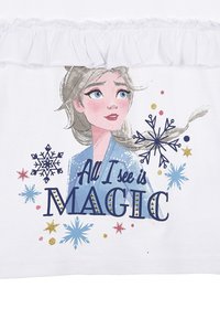Camiseta blanca con una ilustración de un personaje que tiene cabello gris, ojos azules y un atuendo de color azul claro, adornado con copos de nieve y acentos de purpurina.