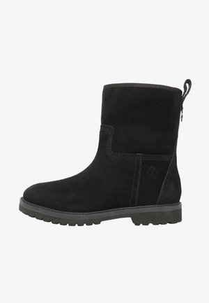 Botte mi-mollet en daim noir avec semelle robuste, languette à l'arrière et logo discret embossé sur le côté.