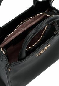 Zwarte leren handtas met hardware in goudkleur, ritssluiting en een gestructureerde afwerking. Het interieur heeft een patroonvoering en meerdere vakken.