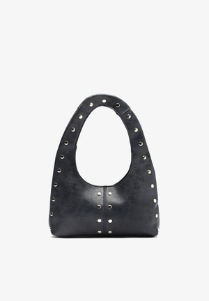Black leather handbag with rounded handle and silver metal studs along edges and center front, standing upright on white background.