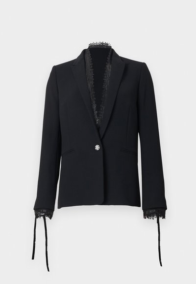 Blazer noir sur mesure avec un seul bouton décoratif, bordure en dentelle le long du col et des poignets, et des rubans attachés aux manches.