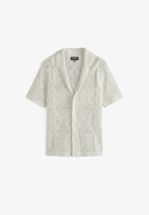 Cárdigan blanco de crochet de manga corta con cuello y botones en la parte delantera, con intrincados patrones abiertos geométricos y florales.