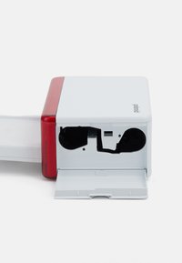 Compact photo printer in white with red accents, featuring a front-loading slot, smooth texture, and open tray for photo output.