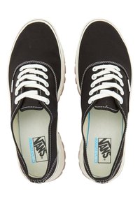 Schwarze Canvas Vans-Sneaker mit weißen Schnürsenkeln, kontrastierenden Nähten und einer hellen Sohle. Das Innere hat ein "ULTRACUSH"-Label.