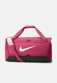 Roze sporttas met zwarte basis, bovenhandgrepen en een schouderriem. Heeft een opvallend wit Nike-logo en ritssluitingen. Gemaakt van duurzaam materiaal.