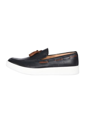 Mocassino slip-on in pelle nera con nappe e dettagli marroni, dotato di suola in gomma bianca.
