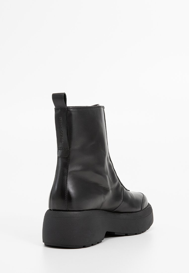 Schwarze Leder-Ankle-Boots mit einem eleganten Design, ausgestattet mit einer flachen, dicken Sohle und einer Lasche auf der Rückseite für ein einfaches Anziehen.