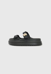 Black sandals with two adjustable straps, gold hardware accents, thick platform sole, and textured footbed. Smooth material finish.